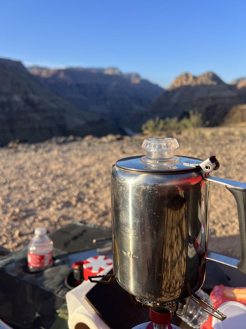 Brewing coffee at sunrise with a canyon backdrop