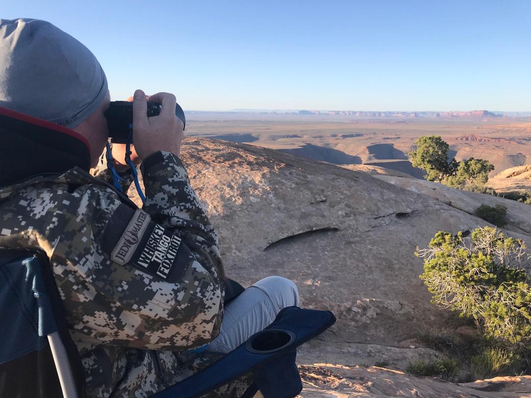 Looking through binoculars over the desert at sunrise