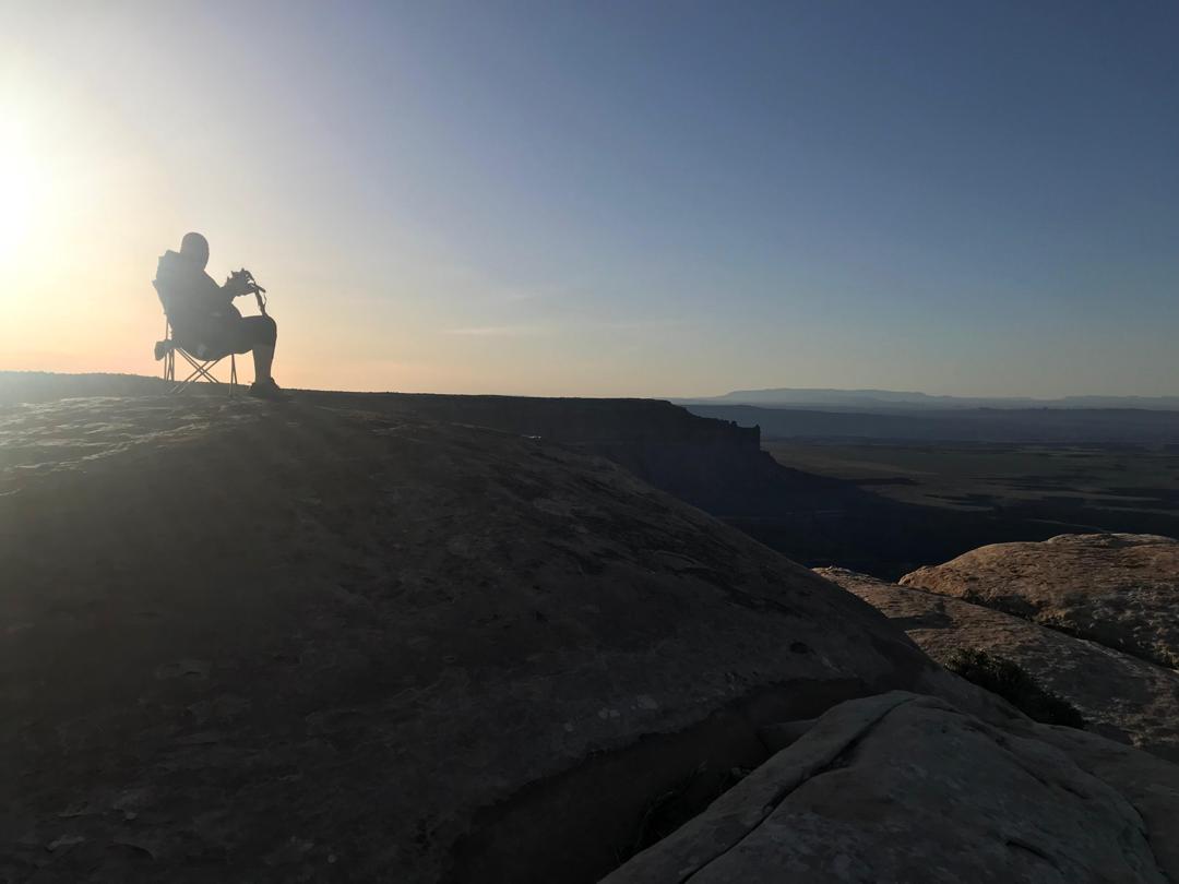 Silhouette of camper relaxing at sunset