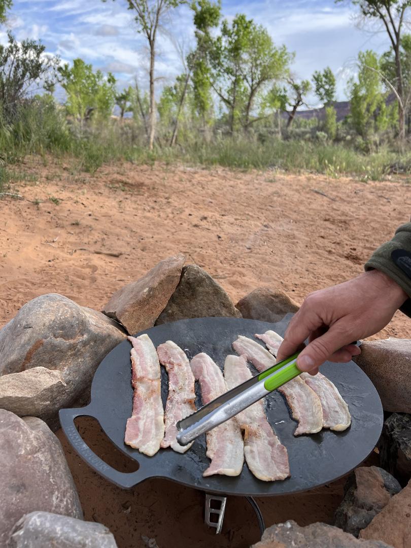 Outdoor bacon cooking on a campfire