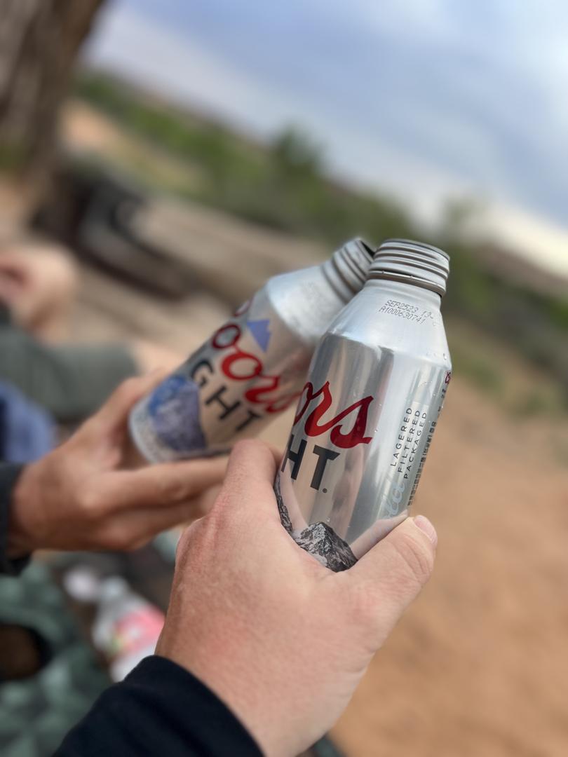 Campers cheering with beer by the fire