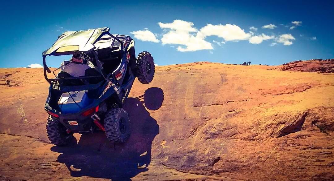 UTV climbing steep red rock in Utah