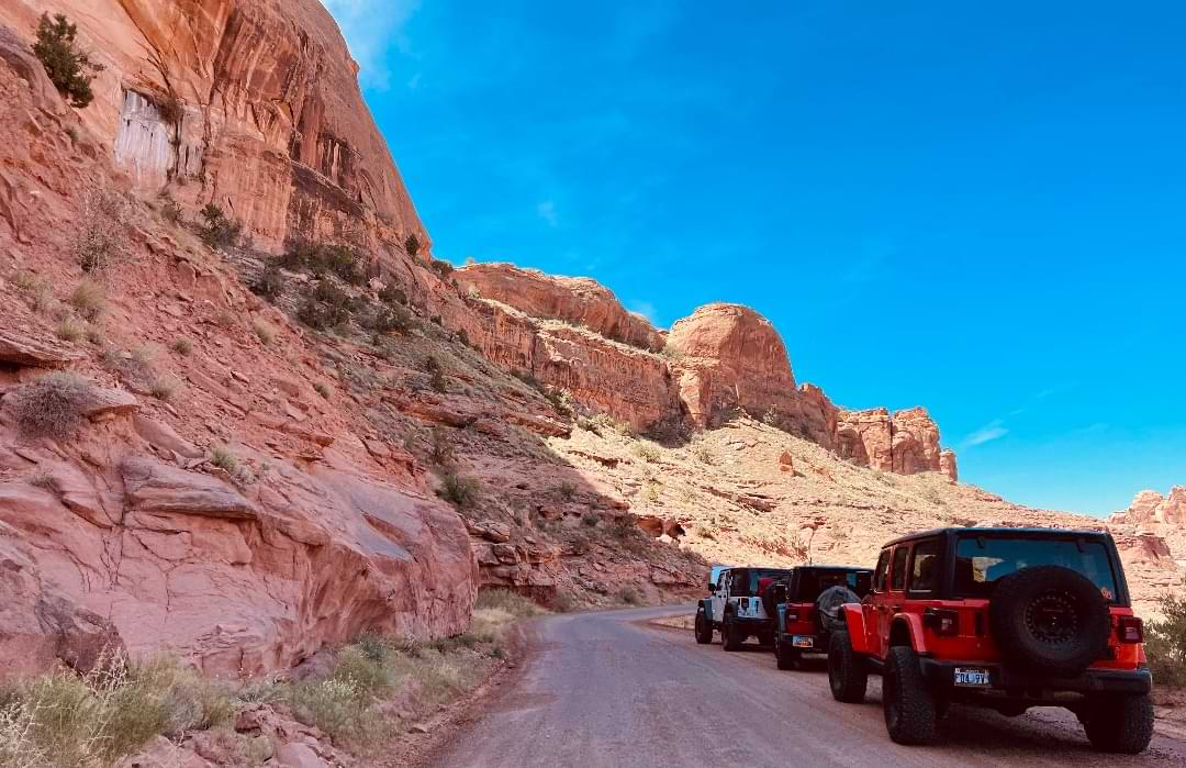 Jeep convoy on scenic canyon road in Moab