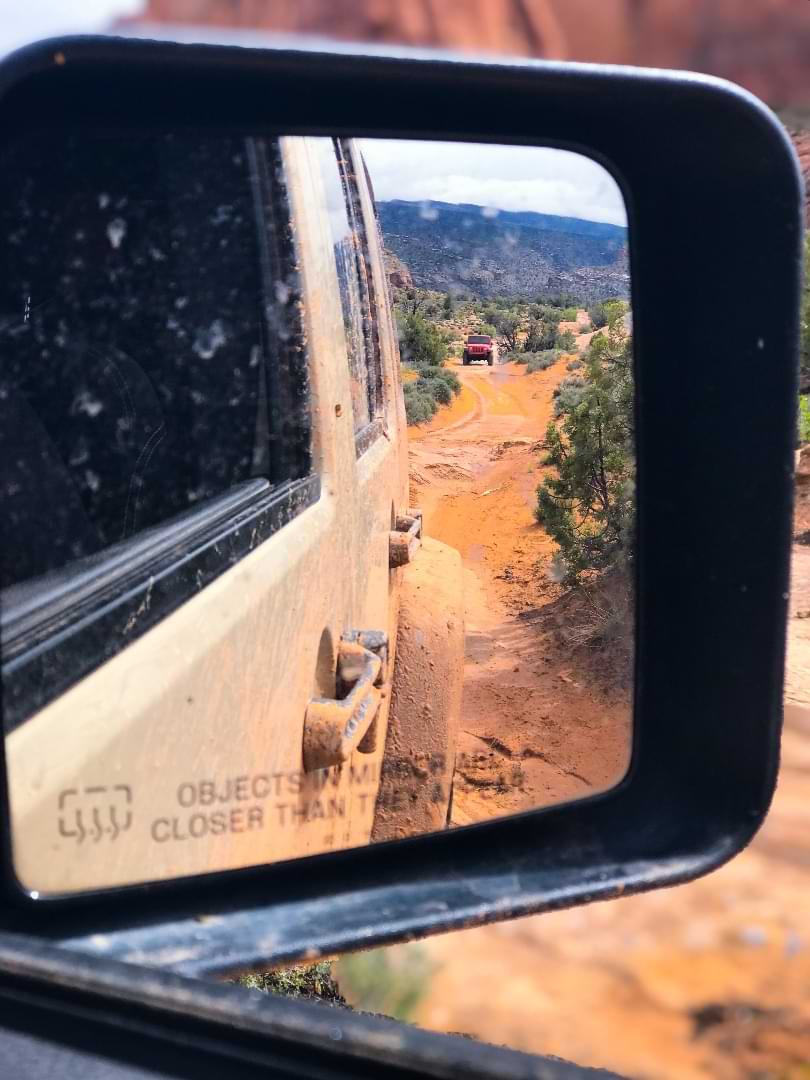 Rearview mirror showing Jeep offroad trail
