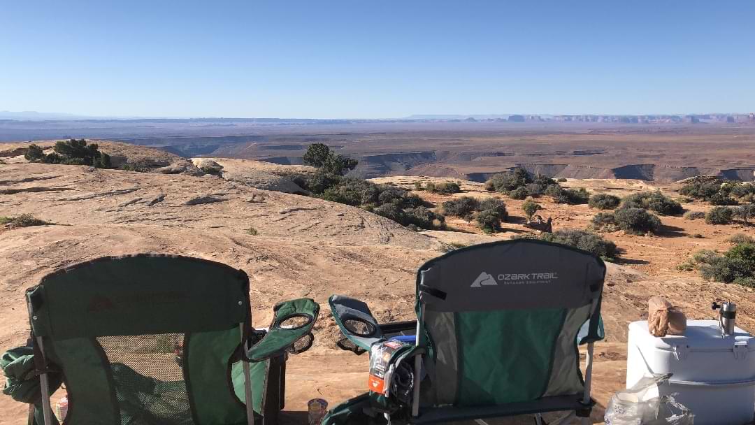 Camping spot beneath towering red rock cliffs